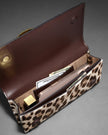 TWISTED GOLD SIDE HANDLE CLUTCH PURSE IN METALLIC LEOPARD